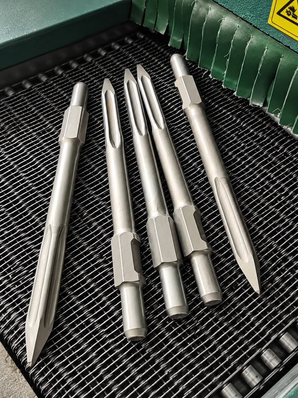 Point chisels passing through the mesh-belt furnace during heat treatment