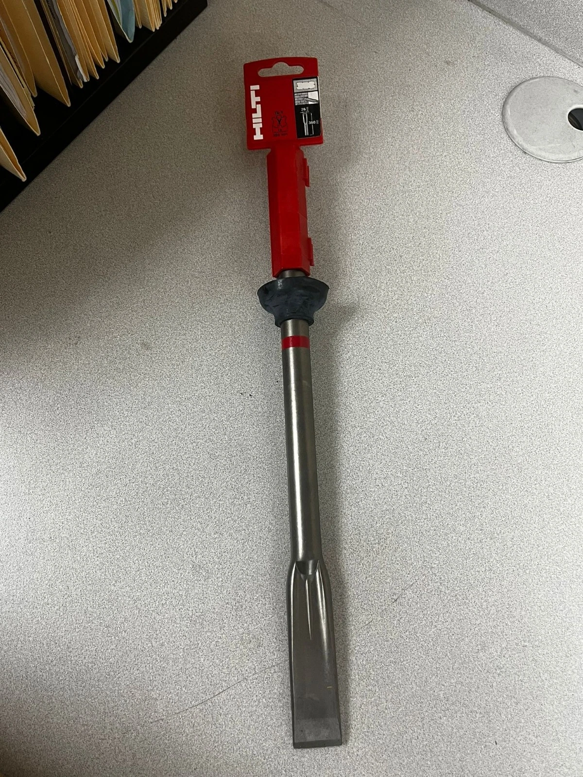 Vollständiger Hilti TE-YX FM Flachmeißel mit 360 mm Länge, Staubkappe und roter Verpackung auf einer Arbeitsplatte